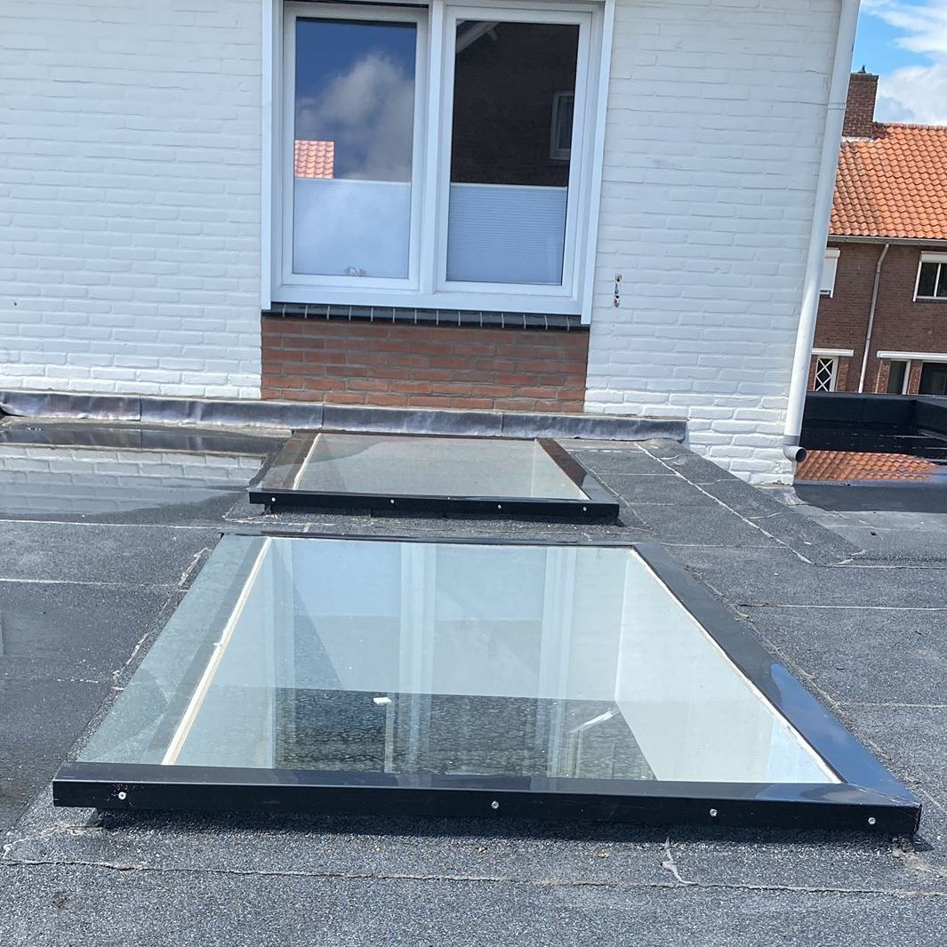 Twee nieuwe glazen dakramen op een plat dak